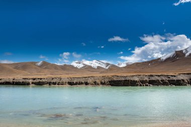 Bulutlu havada karlı dağ deresi.