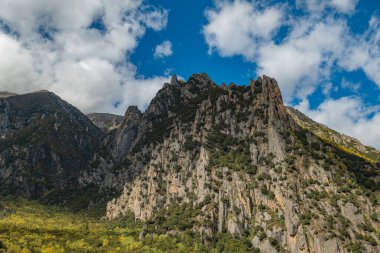 Arkasında dağlar, kayalar ve bulutlar olan güzel dağ manzarası