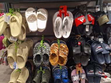 Surabaya-14 Şubat 2024: Çeşitli model ve markalardan oluşan bir sandalet koleksiyonu spor istasyonundaki vitrine asıldı.