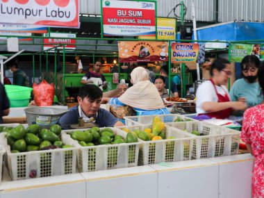 Malang-08 Ekim 2023: Malang 'da geleneksel bir pazarda alıcıları bekleyen avokado satıcılarının fotoğrafı