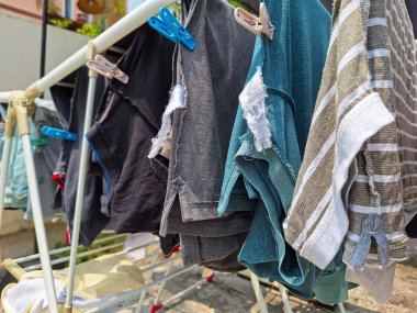 Kurutulan bir grup gömlek ve şortun fotoğrafı.