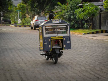 Surabaya-18 Ağustos 2023: Seyyar gıda tedarikçileri ev kompleksi etrafında yürürken mallarını satıyorlar. Çok sıkı çalışıyorlardı..