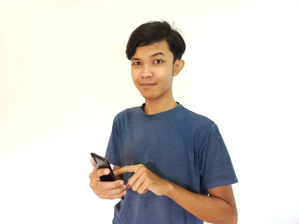 幸せな笑顔アジアの男は彼の携帯電話で遊んで 指摘されたスマートフォン — ストック写真