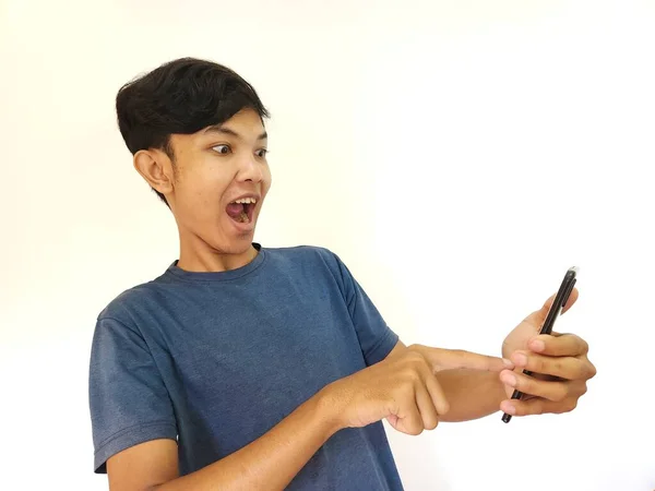 アジア人男性はスマートフォンから見た後ショックと驚き — ストック写真