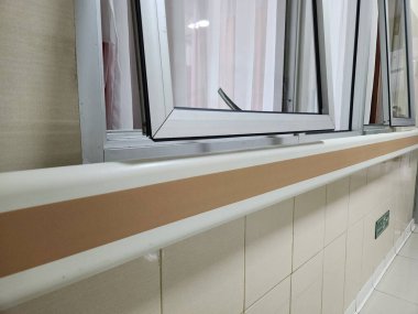 Hastane duvarı tırabzanı hastane koridorunda yürüyen hastalar için destek aracı görevi görüyor.