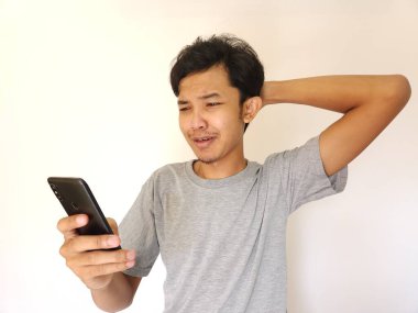 Üzgün adam telefon ekranına bakıyor.