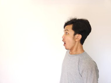 Beyaz arka planda yalnız yaşayan Asyalı adamın şok olmuş ve şaşırmış yüzü.