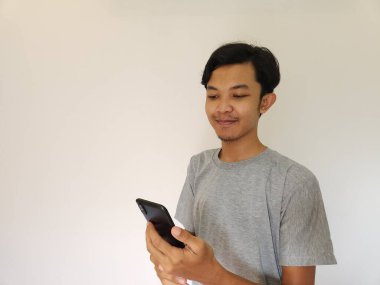 Vay ve sürpriz yüz Asyalı adam akıllı telefon ve reklam alanı kullanıyor.