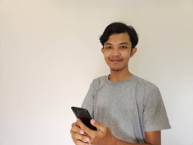 Vay ve sürpriz yüz Asyalı adam akıllı telefon ve reklam alanı kullanıyor.