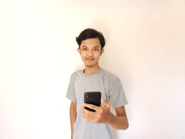 Vay ve sürpriz yüz Asyalı adam akıllı telefon ve reklam alanı kullanıyor.