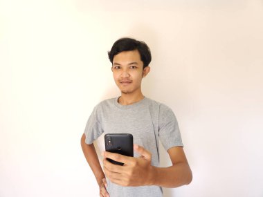 Vay ve sürpriz yüz Asyalı adam akıllı telefon ve reklam alanı kullanıyor.