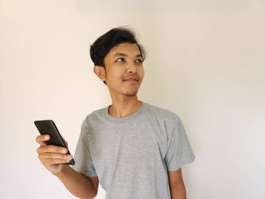 Sürpriz Asyalı adam akıllı telefon kullanıyor ve reklam alanının fotokopisini çekiyor.