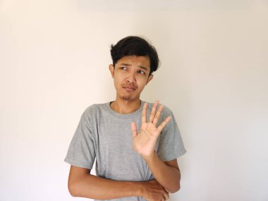 Asyalı adam reddetme işareti gösteriyor, hayır diyor, dur. beyaz üzerine izole