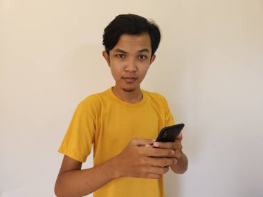 Mutlu gülümseme cep telefonunda daha iyi bir uygulama bulan Asyalı adam.