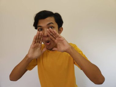 Komik Asyalı adam beyaz arka planda gizli bir dedikodu fısıldıyor.