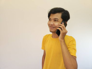 Gri arka planda hazır bekleyen neşeli Asyalı bir gencin portresi