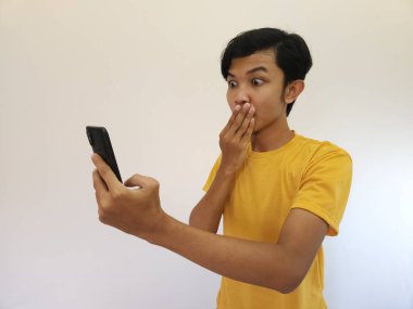 Mutlu gülümseme cep telefonunda daha iyi bir uygulama bulan Asyalı adam.