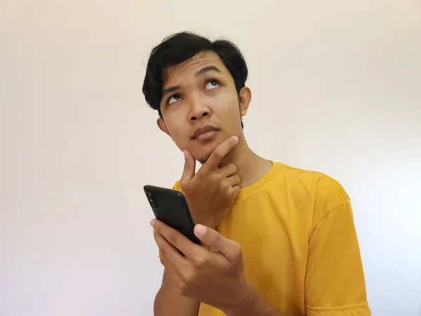 Азиатский Мужчина Держит Мобильный Телефон Глядя Пространство Копирования — стоковое фото