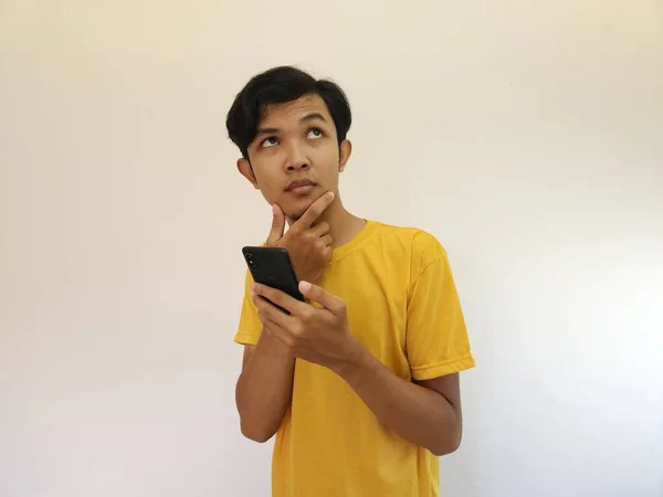 Azji Człowiek Trzyma Telefon Komórkowy Patrząc Górę Przestrzeń Kopiowania — Zdjęcie stockowe