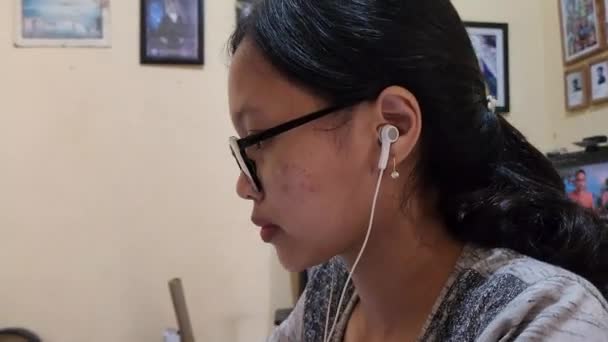 Kadın Dizüstü Bilgisayarla Ödev Yapmaya Kulaklıkla Müzik Dinlemeye Odaklanmış — Stok video