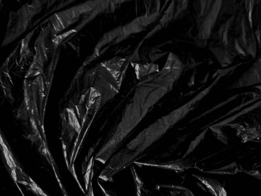 Siyah arka planda şeffaf plastik ambalaj. Temiz boş doku kaplama etkisi şablonu. İzole edilmiş kırışık yüzey damgalama modeli.