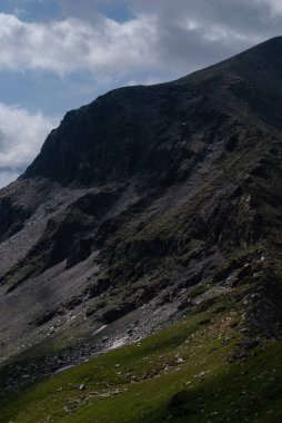 Dağları ve mavi gökyüzü olan güzel bir manzara.