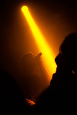 Elinde mikrofon olan bir adamın silueti.