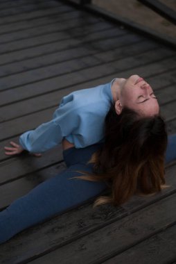 Bulutlu ve yağmurlu bir havada parkta ayrılan bir kız görülüyor.