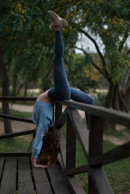 Parktaki sporcu kız akrobasi yapıyor.