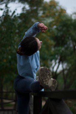 Spor kızı manzarası parkta esneme egzersizleri yapıyor. 
