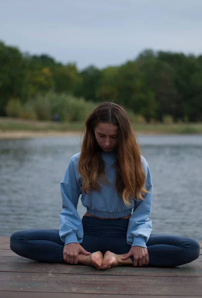 stock image View of a girl in Lotus Pose near lake in rainy weather