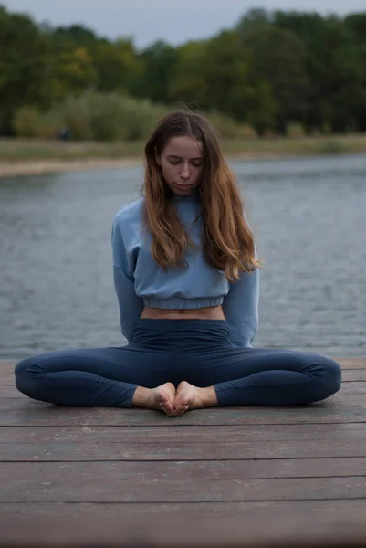 stock image View on a girl in Lotus Pose near lake