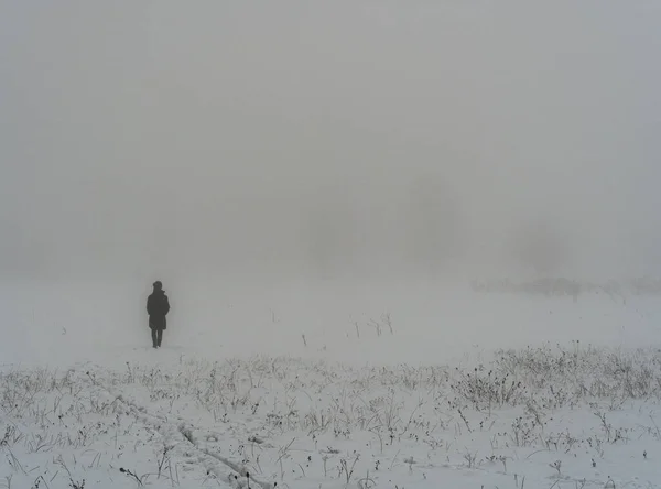 Woman slowly disappears fog and snow