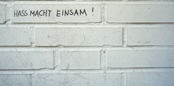 Tło Obrazem Ściany Cegły Stwierdzeniem Hass Macht Einsam — Zdjęcie stockowe