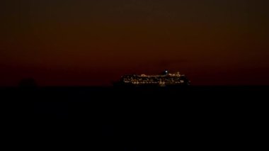 Gece okyanusunda turistik gemilerin aydınlatılmış güverteleri.