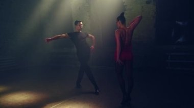 Yan manzara balo dansçıları tutkulu tango dansçıları yüz yüze, birbirlerine yaklaşıyorlar, erkek kadını elleriyle yakalıyor, ona doğru hamle yapıyor, kadın ayağı yana sallıyor, dans desteği veriyor. Çatı katı atmosferi