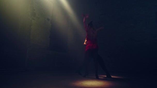 ボールルームダンサーのシルエットは 上記の脇から来る拡散日光の光の下で放棄されたロフトダンスタンゴの暗闇の中でペア 情熱的な同期手の動き 回転とサポート — ストック動画
