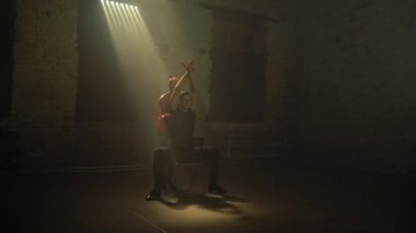 Ballroom dancers pair in abandoned old building performs passionate tango dance,man on chair,as if waking up from dream.Woman in red mini stage dress.Soft natural light source,cinema art atmosphere 