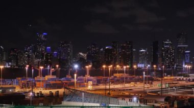 Miami Limanı, Florida 'daki gece görüşlü kargo terminalleri. Arka planda sokak lambalarıyla aydınlatılan istiflenmiş malların bulunduğu geniş rıhtım alanları. Amerikan Kargo Terminali, yük trafiği.