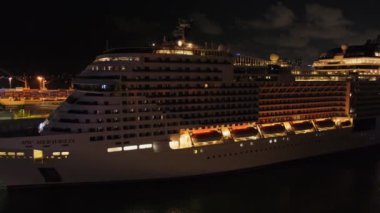 Lüks okyanus gemisinin pruvası geceleyin Miami, Florida 'daki Cruise terminal limanında demirli, ön taraf manzaralı, ağır çekim. Denizcilik turizmi, Atlantik ötesi uluslararası ulaşım 