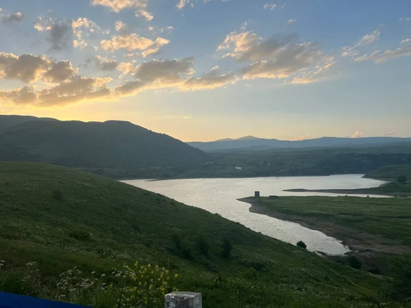 Ermenistan 'daki dağlarda bir gölün üzerinde gün batımı