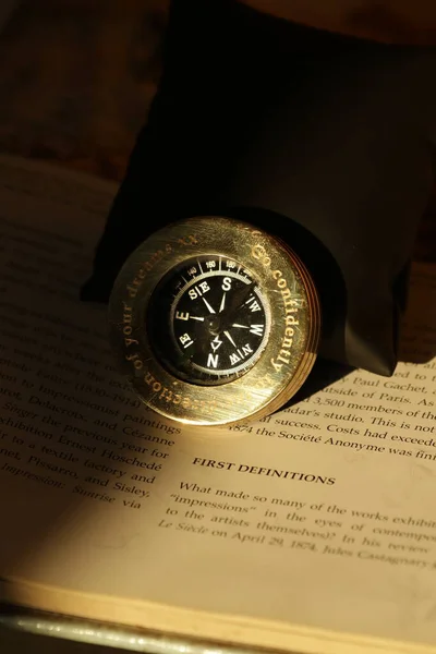 Złoty Kompas Książce Pokrytej Słońcem — Zdjęcie stockowe