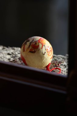 Güneşle aydınlatılan bir pencerenin kenarındaki beyaz Noel süslemesi 