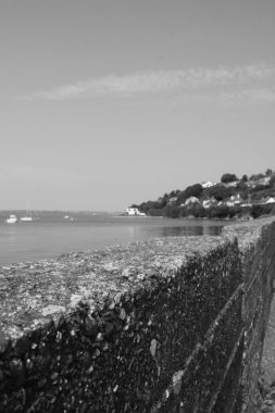 Deniz manzaralı güzel bir plajın ve dağların siyah beyaz fotoğrafı.