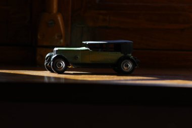 close-up of a retro toy car in front of an old vintage cars