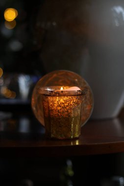 Ahşap bir masanın üzerinde yanan bir mum.