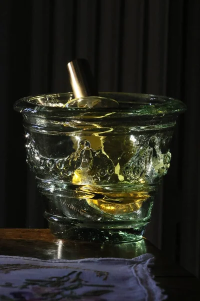 stock image a glass of water and a bottle of lemon on a black background