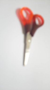 Bulanık ya da odaklanmamış ya da tek ya da bir kırmızı turuncu kahverengi makas izole edilmiş beyaz arka planda.