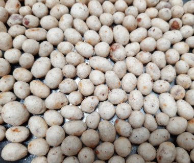 White and brown round nuts and flour snack texture a.k.a. sukro. Indonesian traditional snack made from tapioca flour and nut inside.