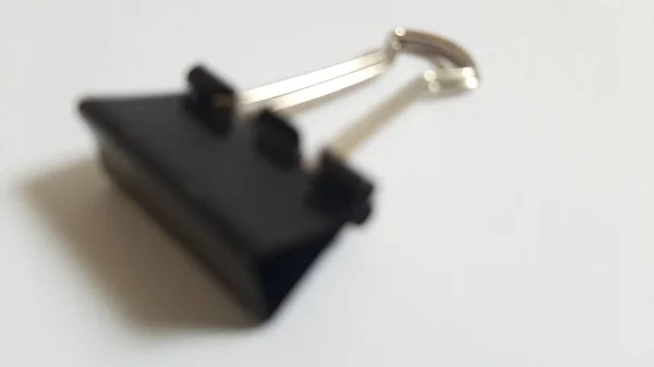 Blurred or unfocused or defocused Binder or paper clip or office bind clip, stationery, realistic object on isolated white background